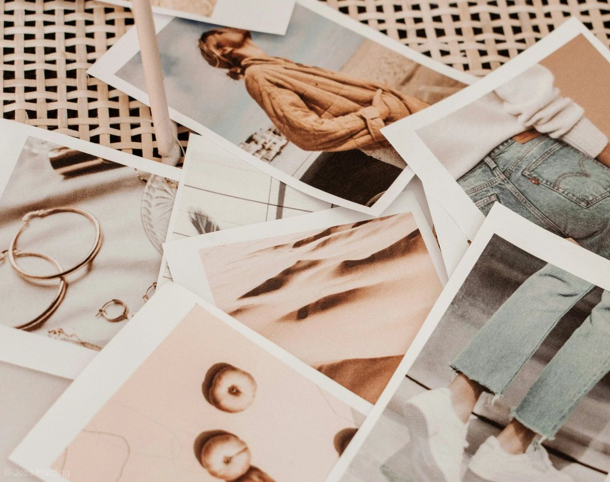 Fashion prints and jewellery laid out on a rattan table